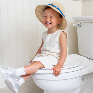 Smiling Toddler Sitting on Deployed Potty Proud Seat on Toilet