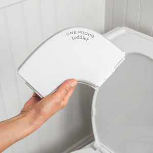 Hand Holding Folded Potty Proud Seat Above Toilet